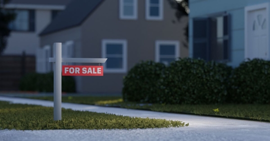 Real estate sign in front of a house for sale in a nice suburban neighborhood